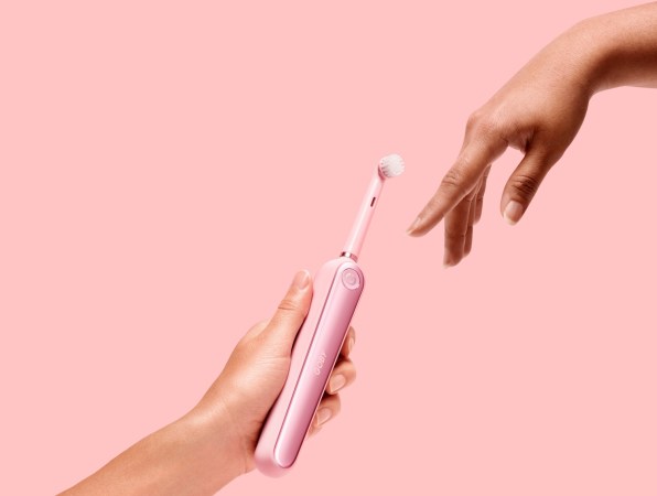 holding pink toothbrush