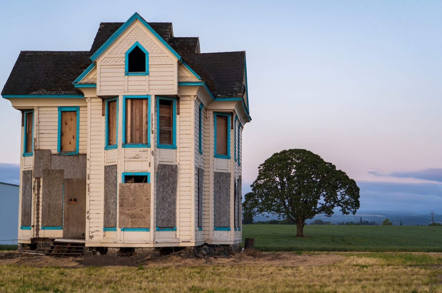 a boarded up house on open land