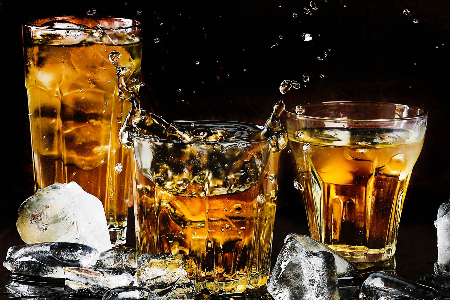 alcohol and ice in multiple glasses