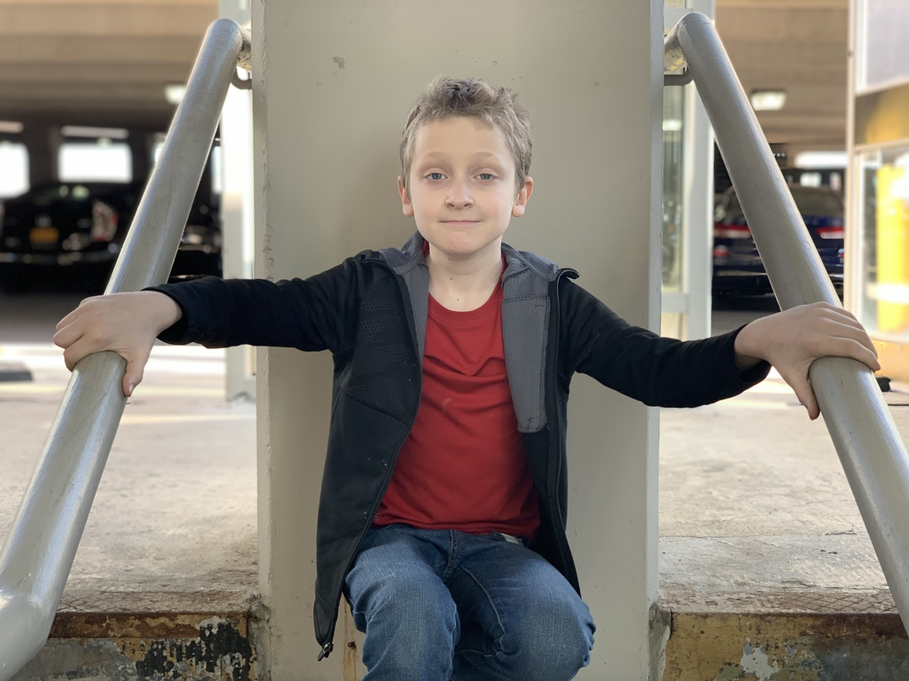 A boy in a jacket sitting down