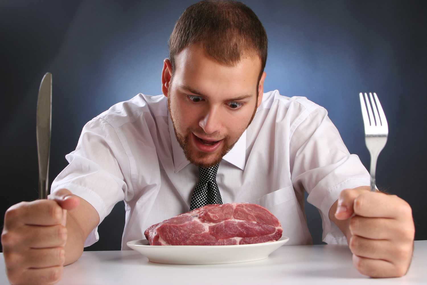 guy in a tie ready to eat raw meat