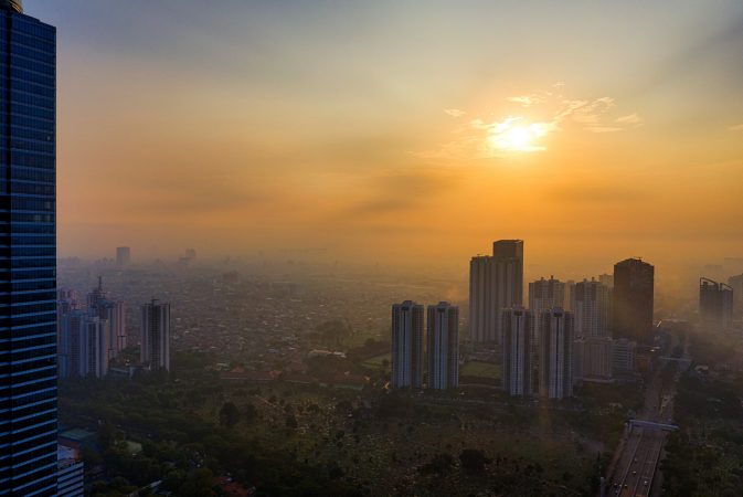 high risk buildings in Jakarta, Indonesia in front of golden sun