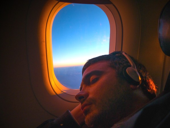 Person sleeping on plane with open window