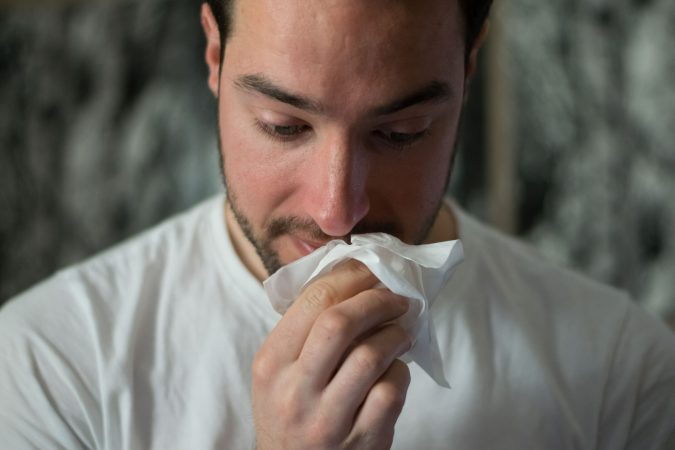 person holding tissue to nose