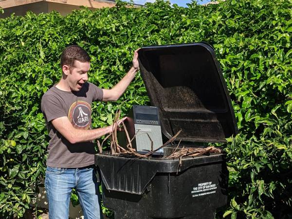 Man opening a trash can.