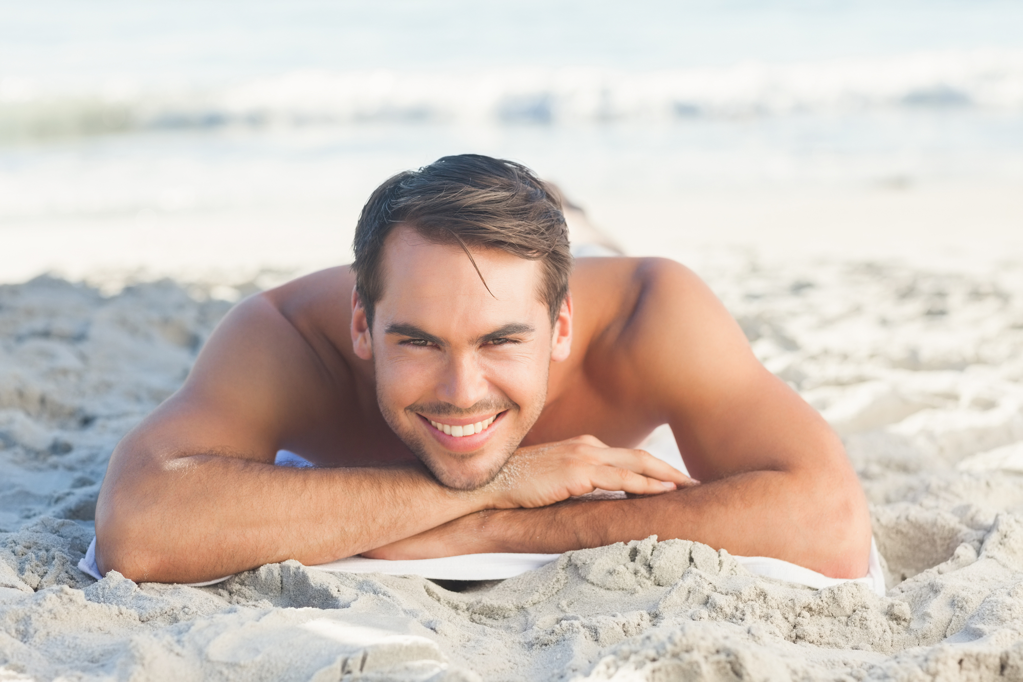 a man lying on the beach