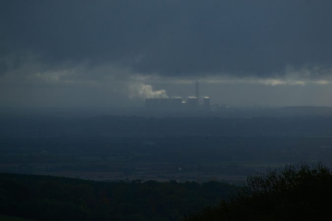 landscape filled with smog with industrial building in the distance