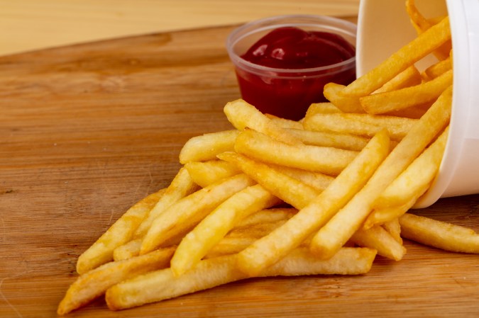 a pile of french fries and a bowl of ketchup