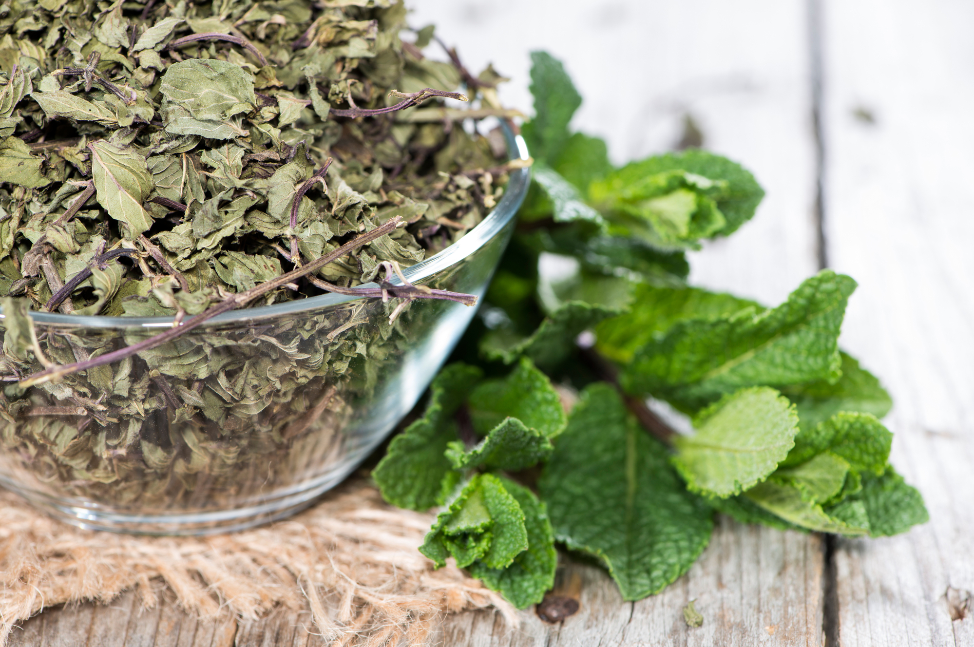 Bowl with dried Mint on vintage wooden background