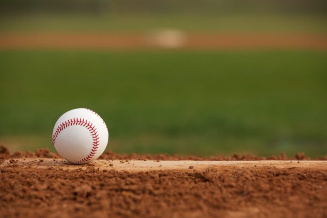 A baseball sits on a pitcher's mound.