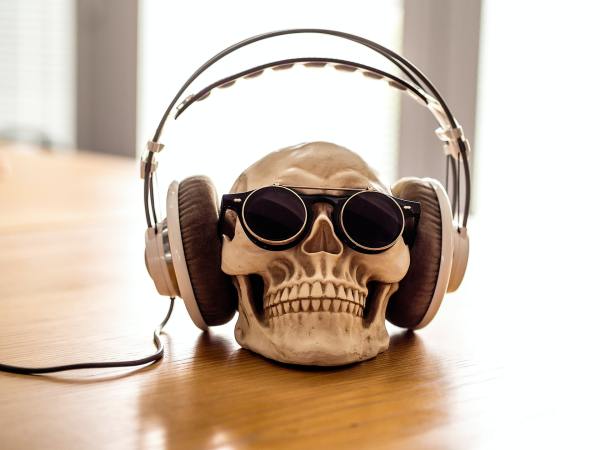 a human skull wearing sunglasses and large headphones