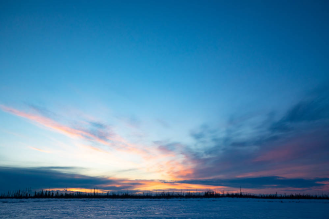 landscape of sun shining over a frozen lake.