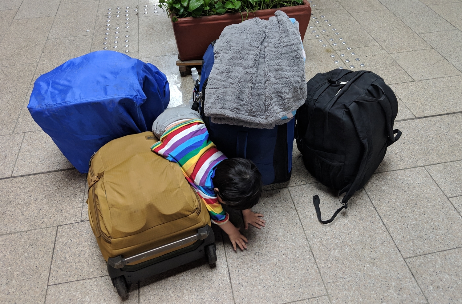 Toddler playing with suitcases at airport