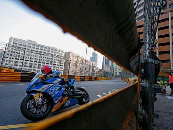 Lee Johnston (BMW Ashcourt Racing) hurtles a short distance from the dreaded Armco barriers, with the city in the background.