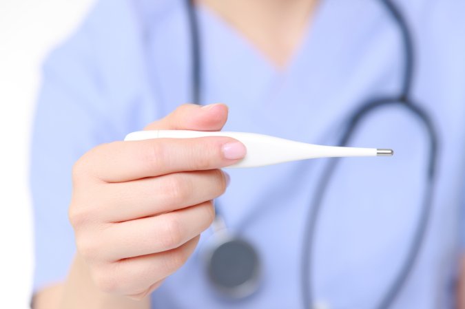 a hand holding a thermometer