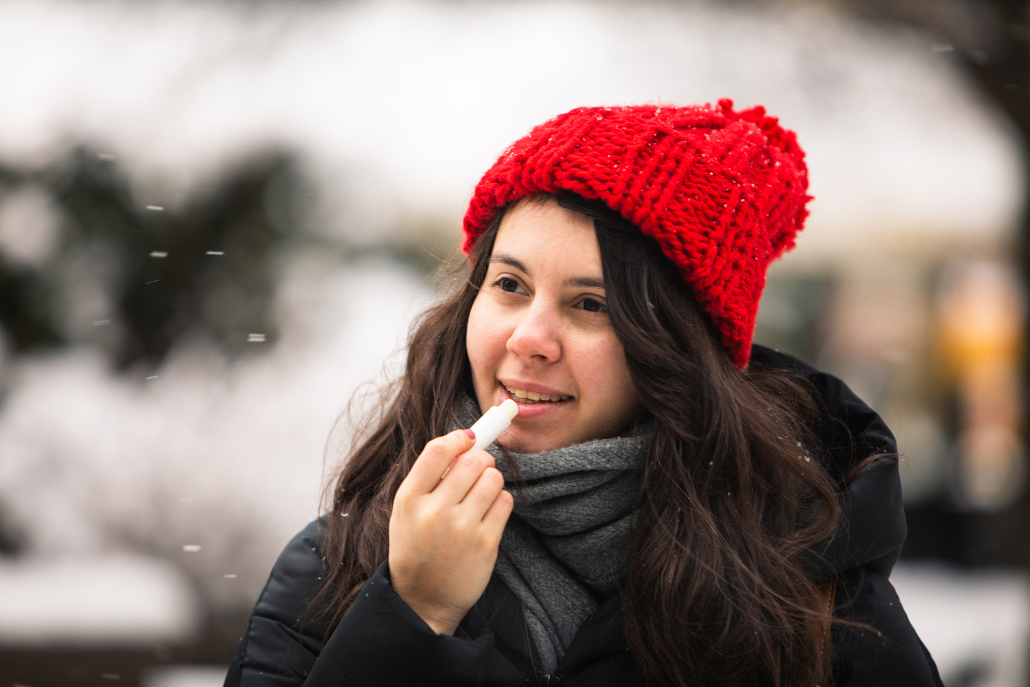 woman using cream at cold winter weather. skin protection. dry face