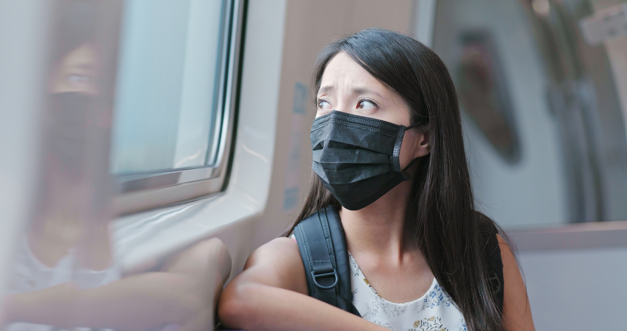 a woman wears a black face mask on the train in Taipei city in taiwan