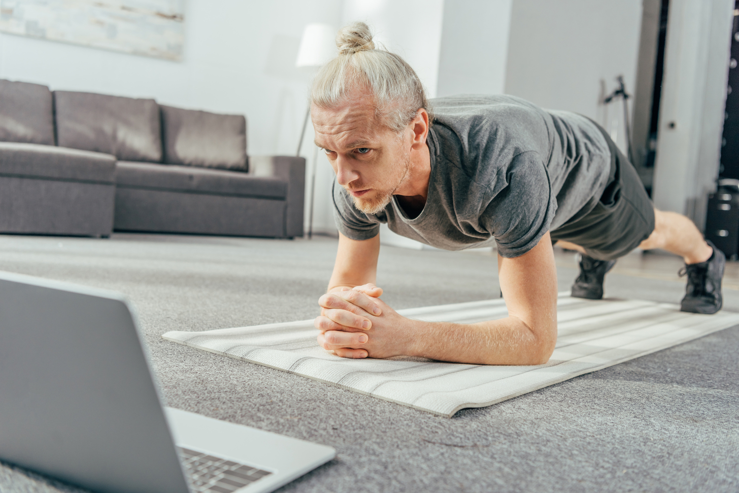 Person working out with a laptop in hotel room.