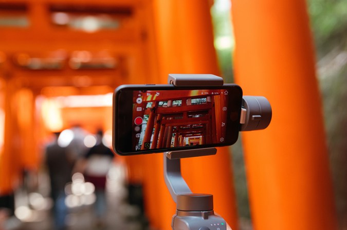 person holding a gimbal and smartphone