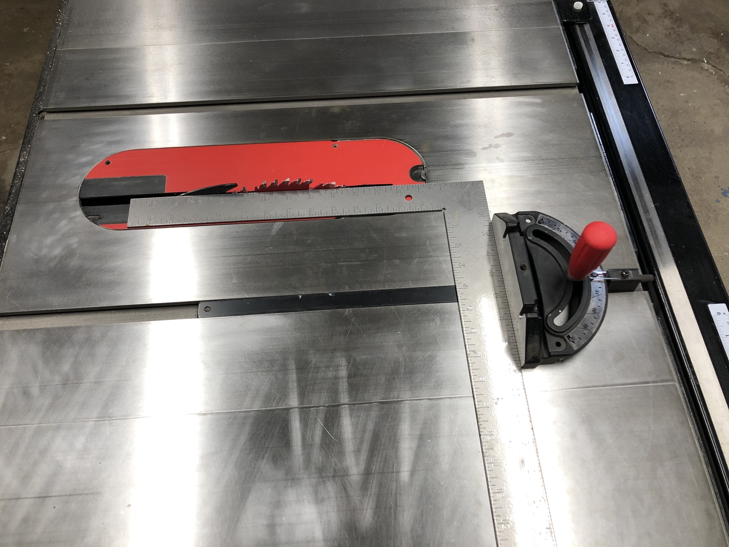 a table saw with a miter gauge and a carpenter's square being used to calibrate the gauge