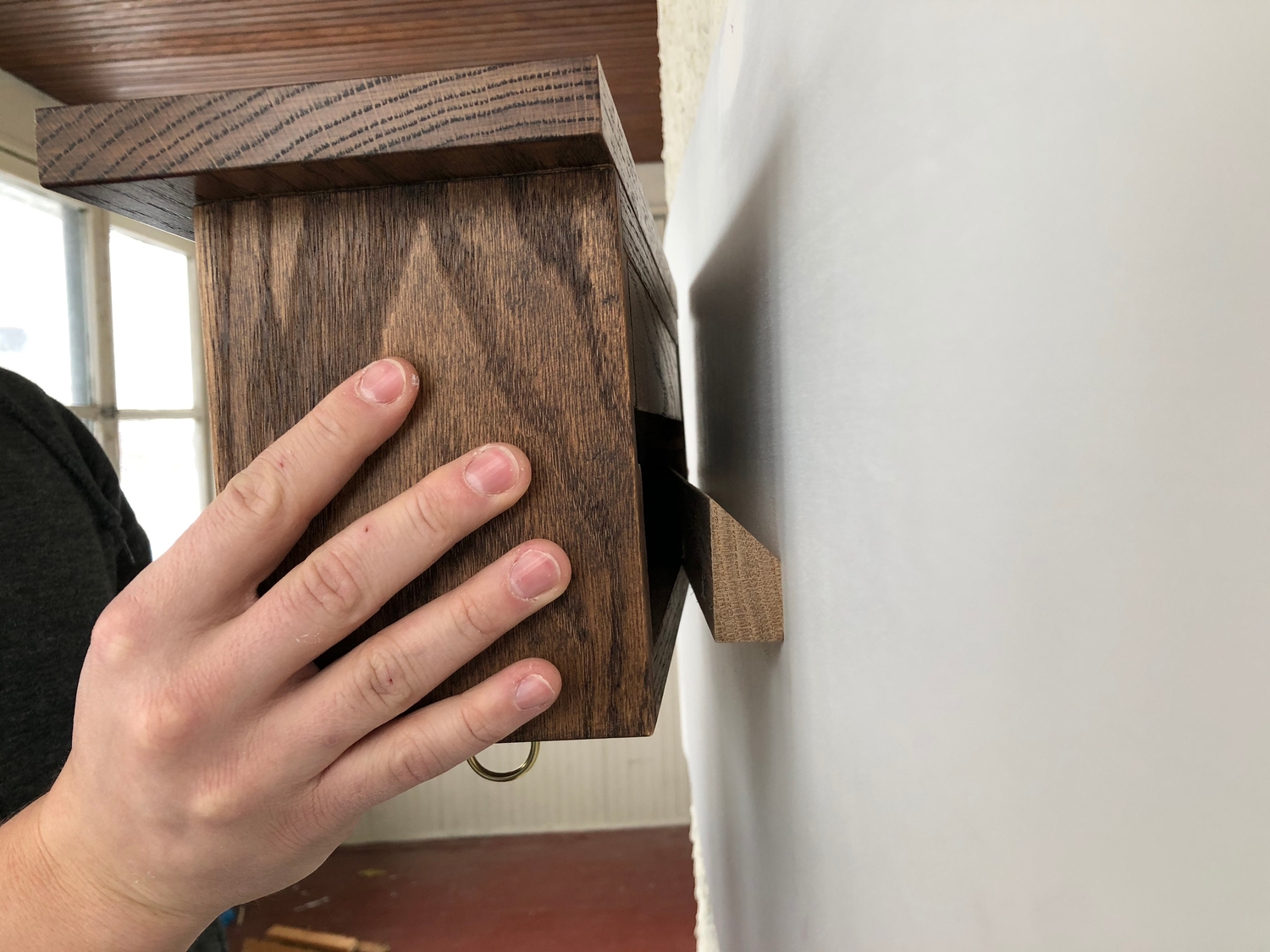 an oak key cabinet shelf that hangs with a French cleat on the wall