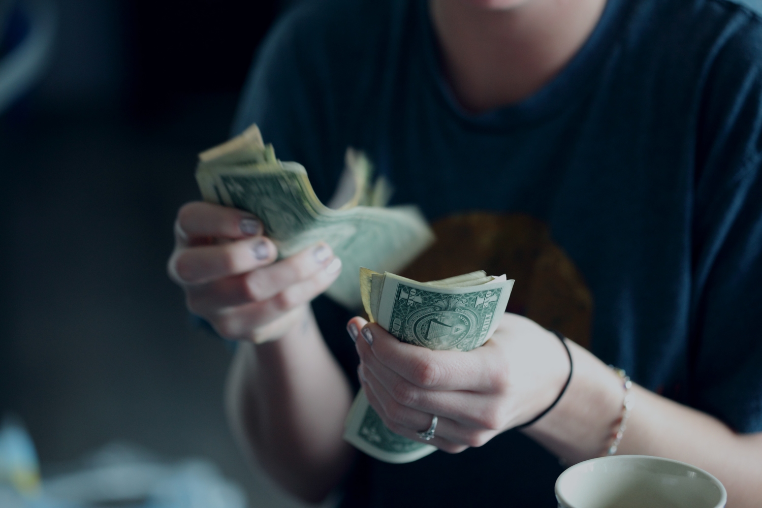 a person counting money in $1 U.S. bills