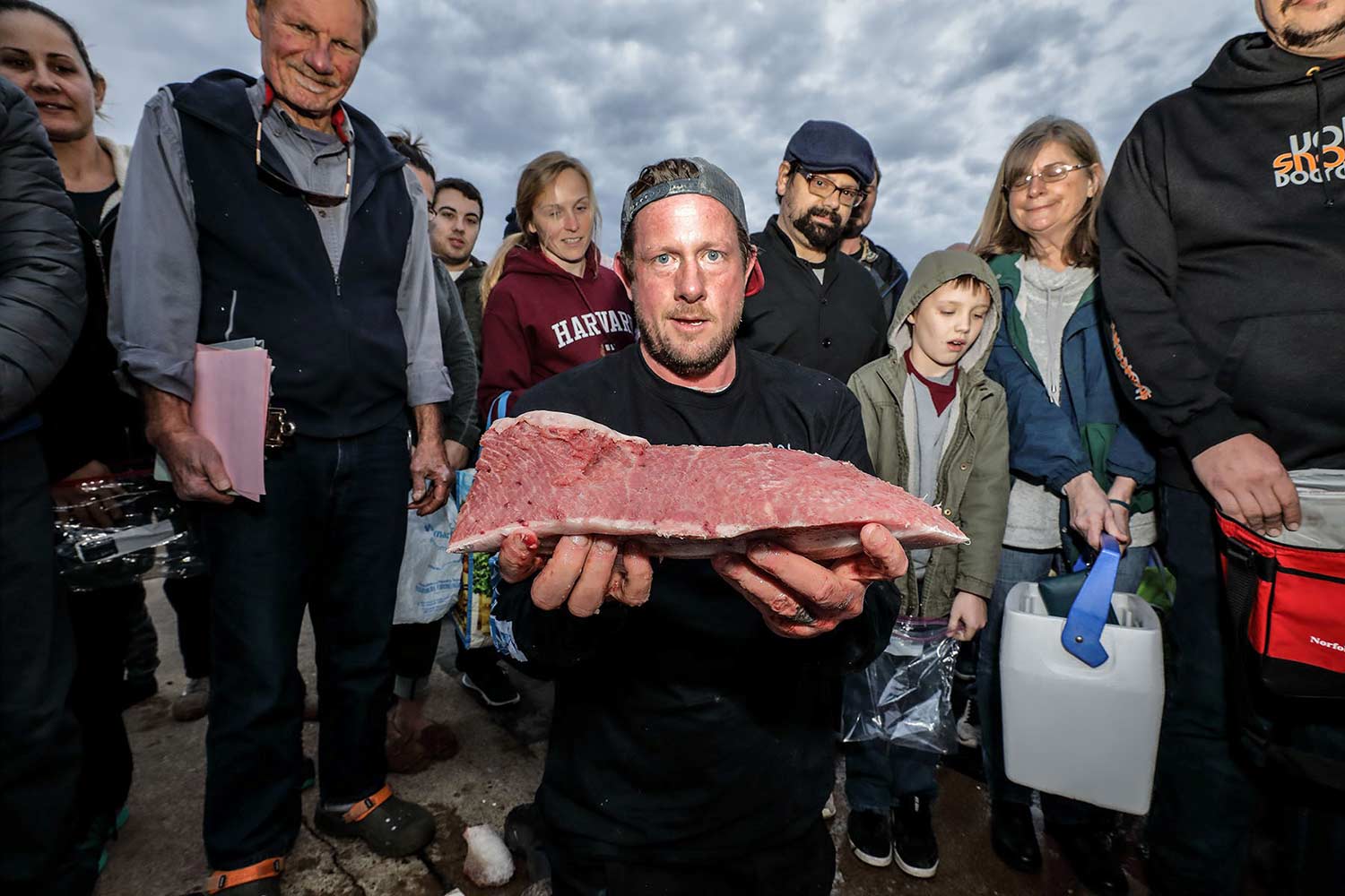 Man holding out a piece of tuna.