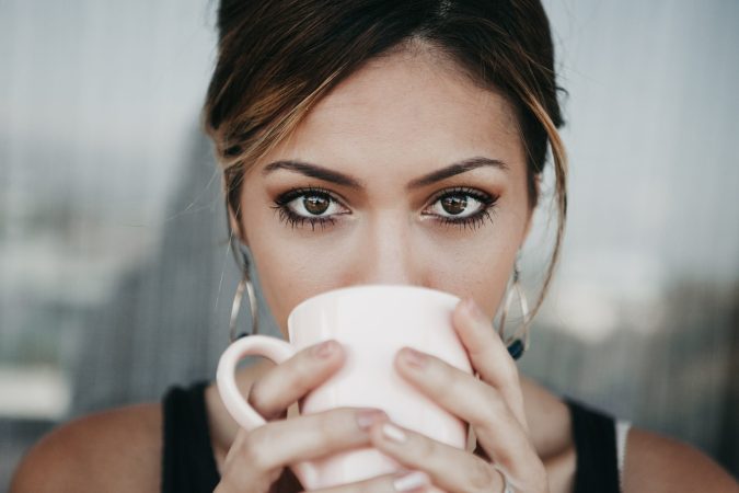 A brown-eyed individual holding a mug