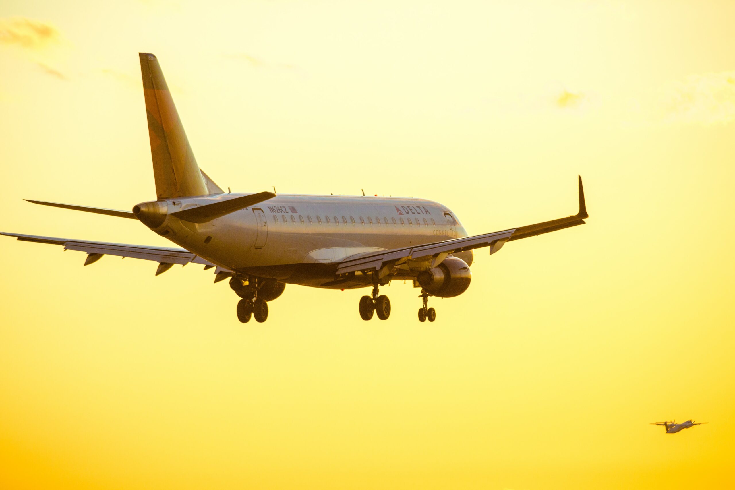 A Delta passenger plane taking off into the sun