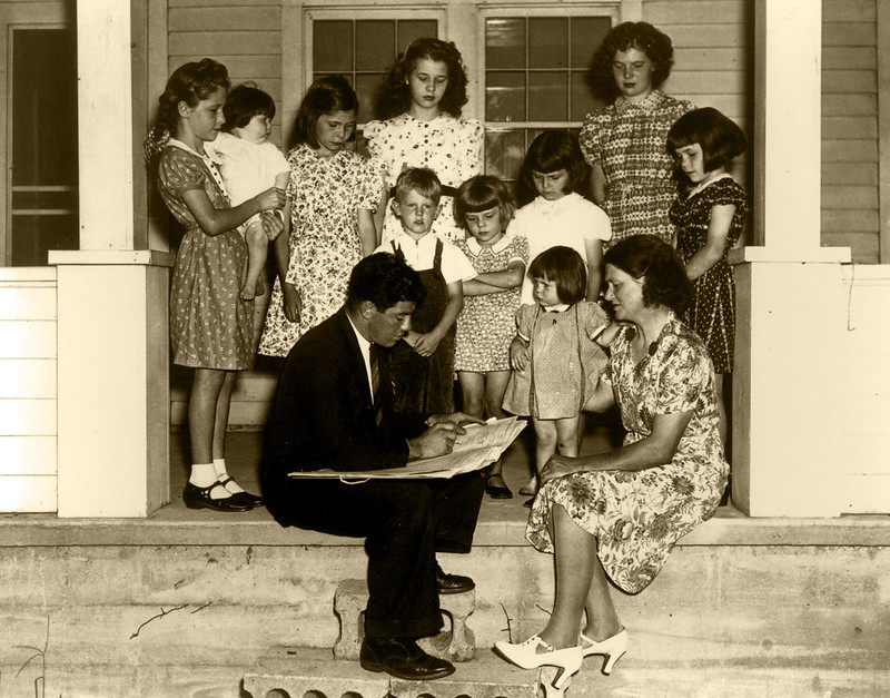 A black and white photo of a census taker with a big family full of children