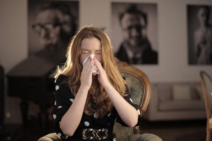 Woman with tissue sneezing