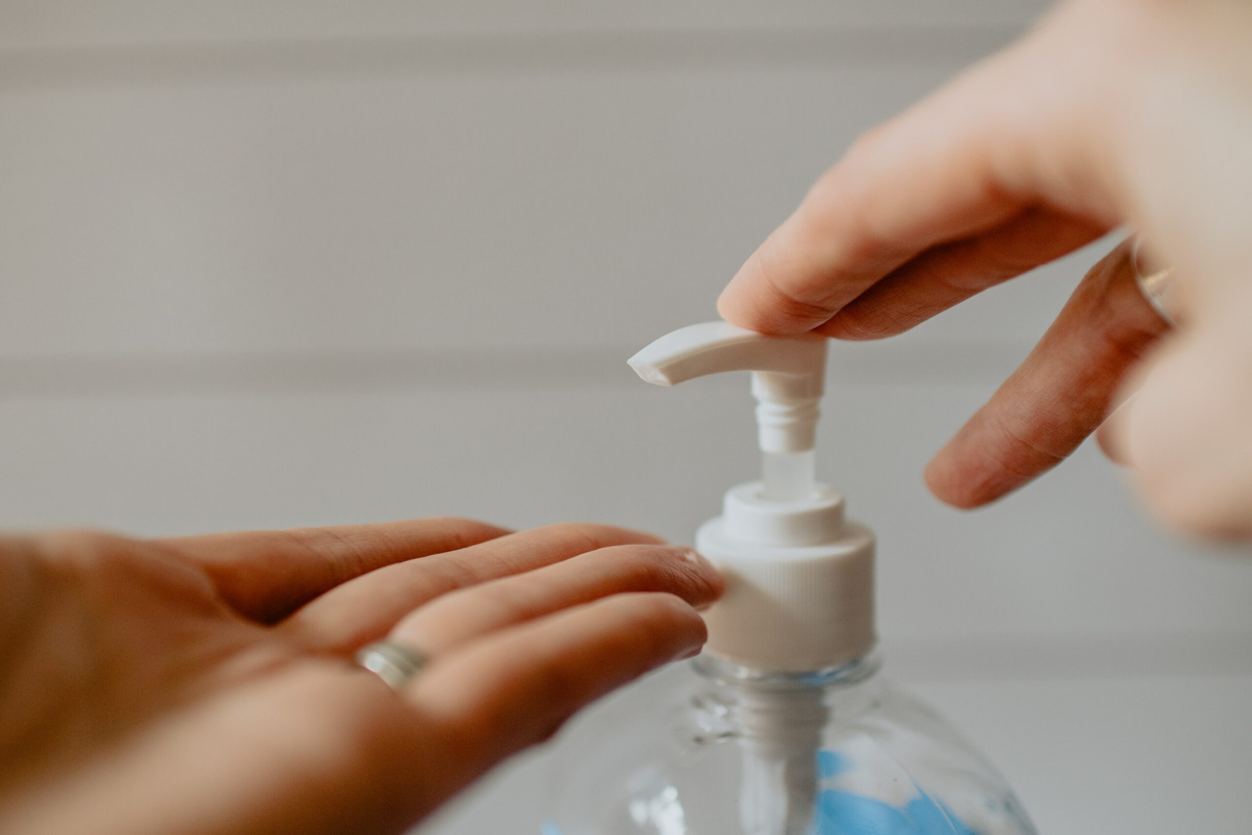 Hand sanitizer bottle and hands.