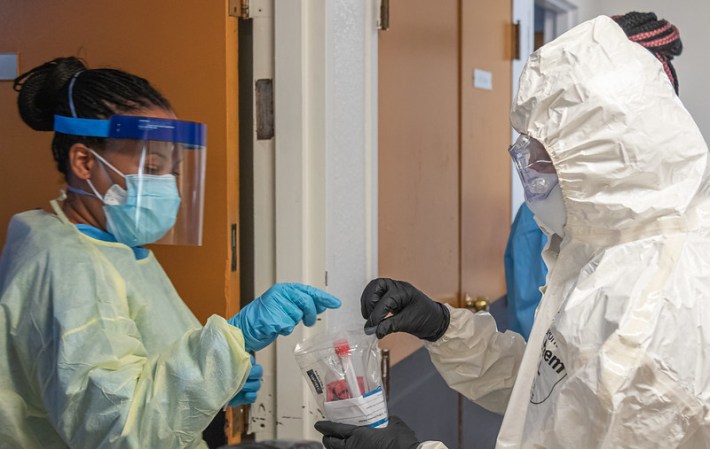 Staff and military personnel at a Florida nursing home secure COVID-19 test samples.