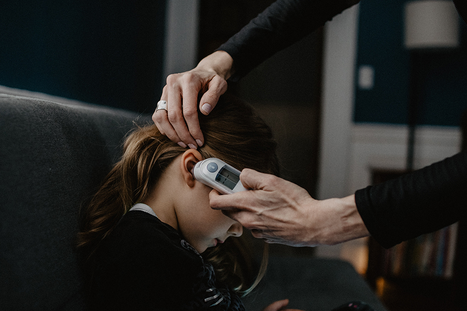 person putting a thermometer in a child's ear
