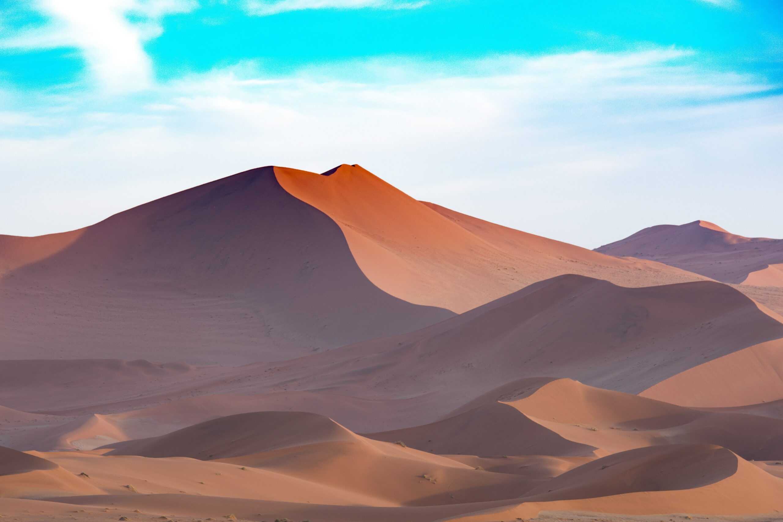 sand dunes in a desert with blue skies