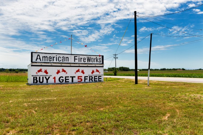 A sign for buy one, get five fireworks for free on a rural Texas highway