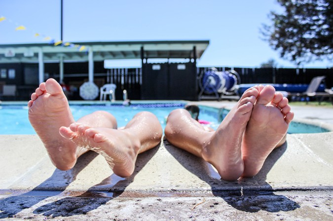 two people in a pool with feet over the side