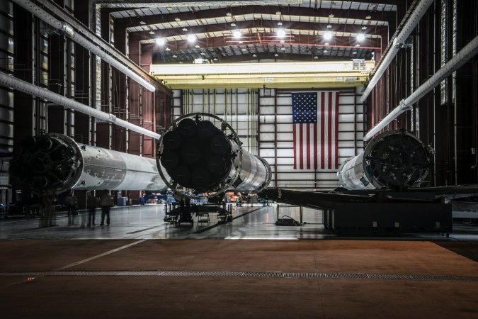 Three rocket parts and an American flag housed at the Kennedy Space Center in Florida.