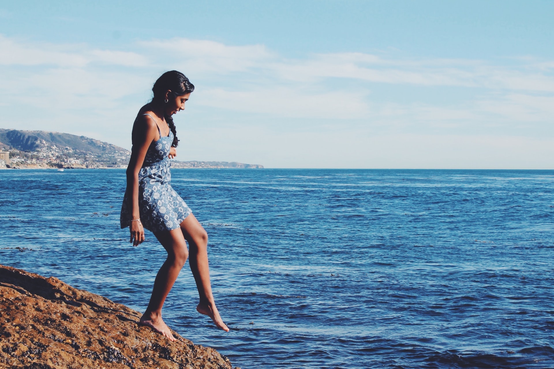 Teenager dipping toes into a lake or ocean