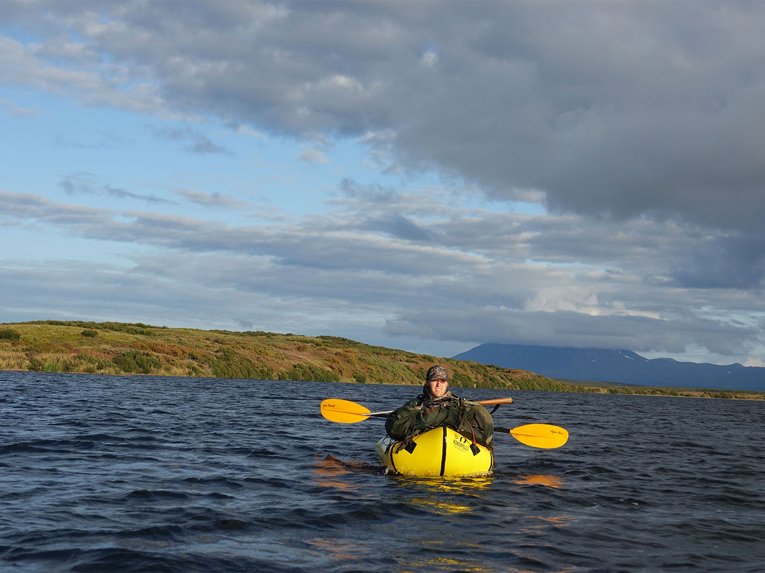 A man in a yellow raft on a lake.