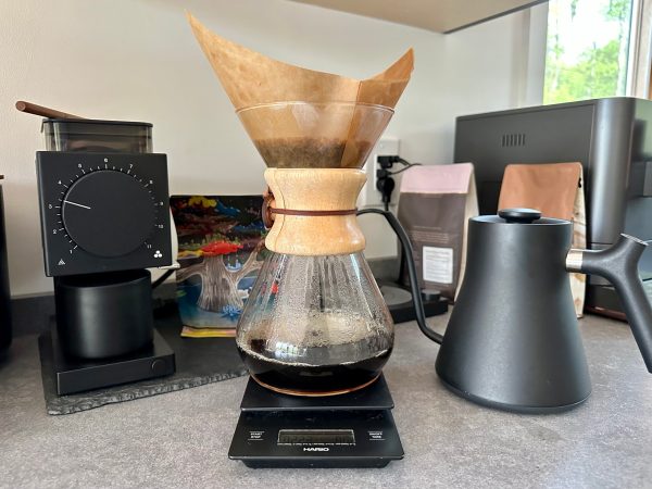  Chemex pour over coffee maker on a counter with coffee, grinder, and kettle