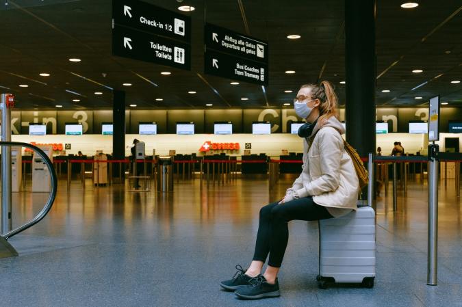 Woman waiting for airplane with coronavirus mask.