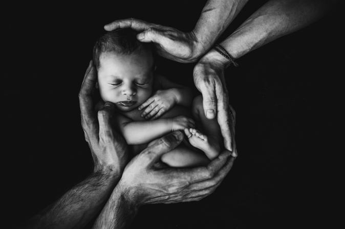 Two parents holding a newborn