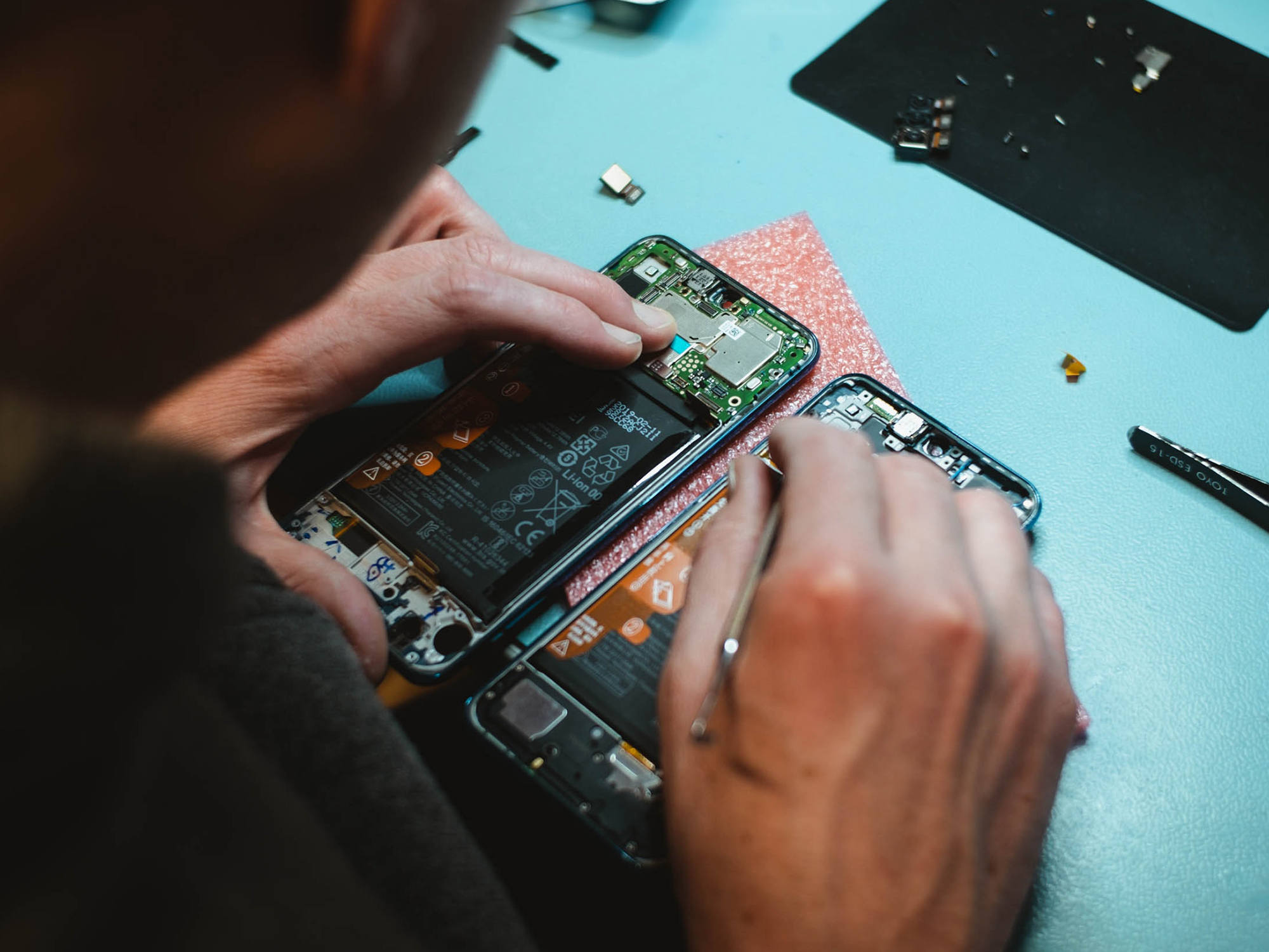 a person working on a disassembled phone