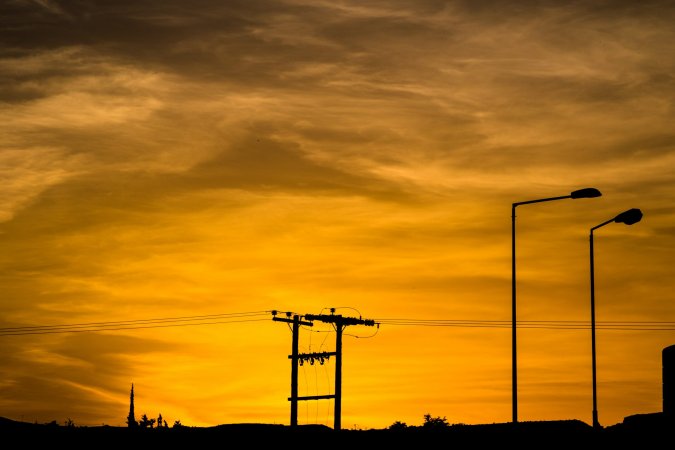 power line silhouette against reddish sunset