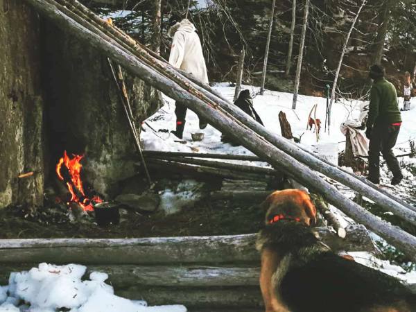 A lean to shelter built on a rock side.