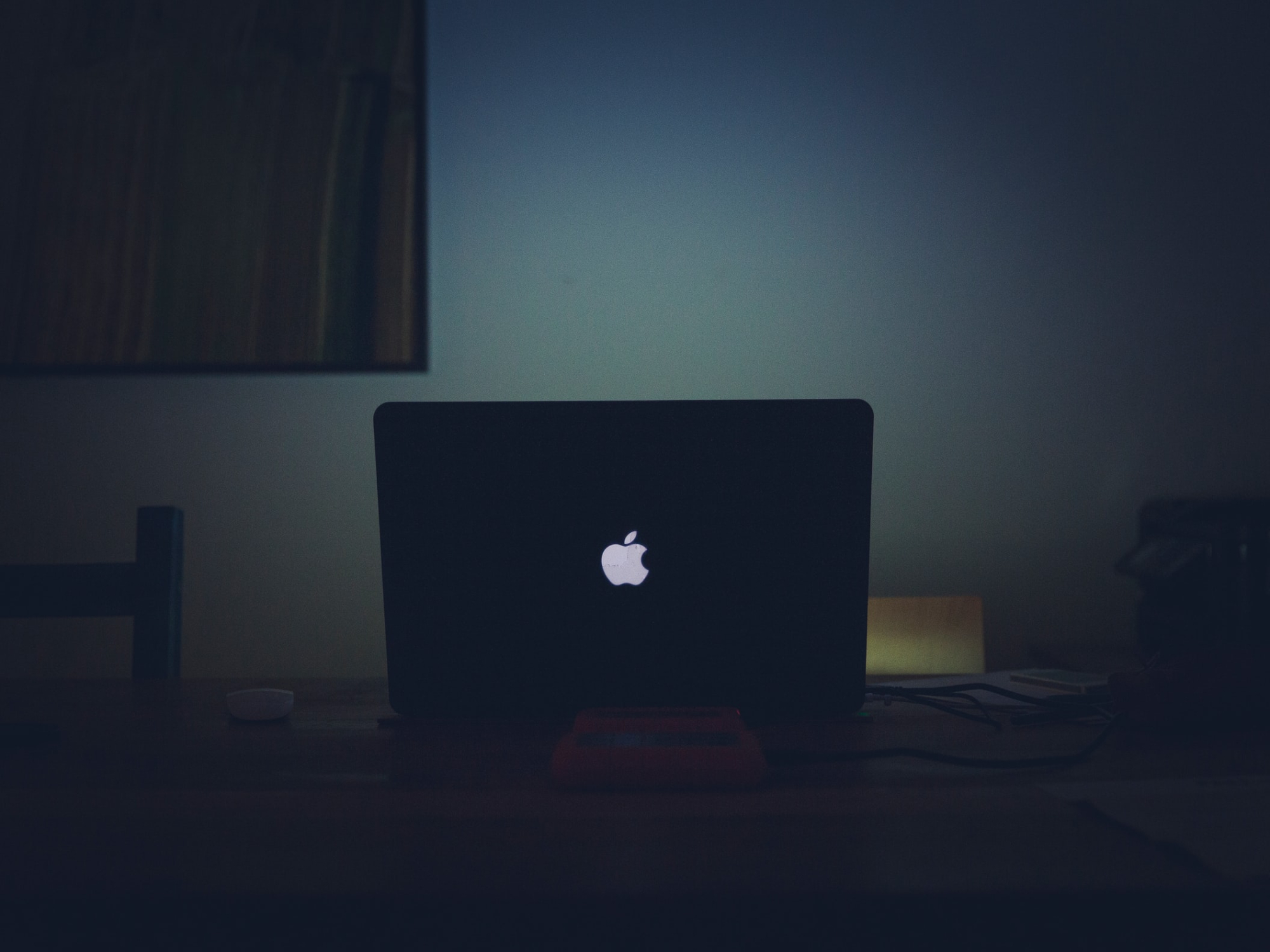 an Apple laptop at night on a table