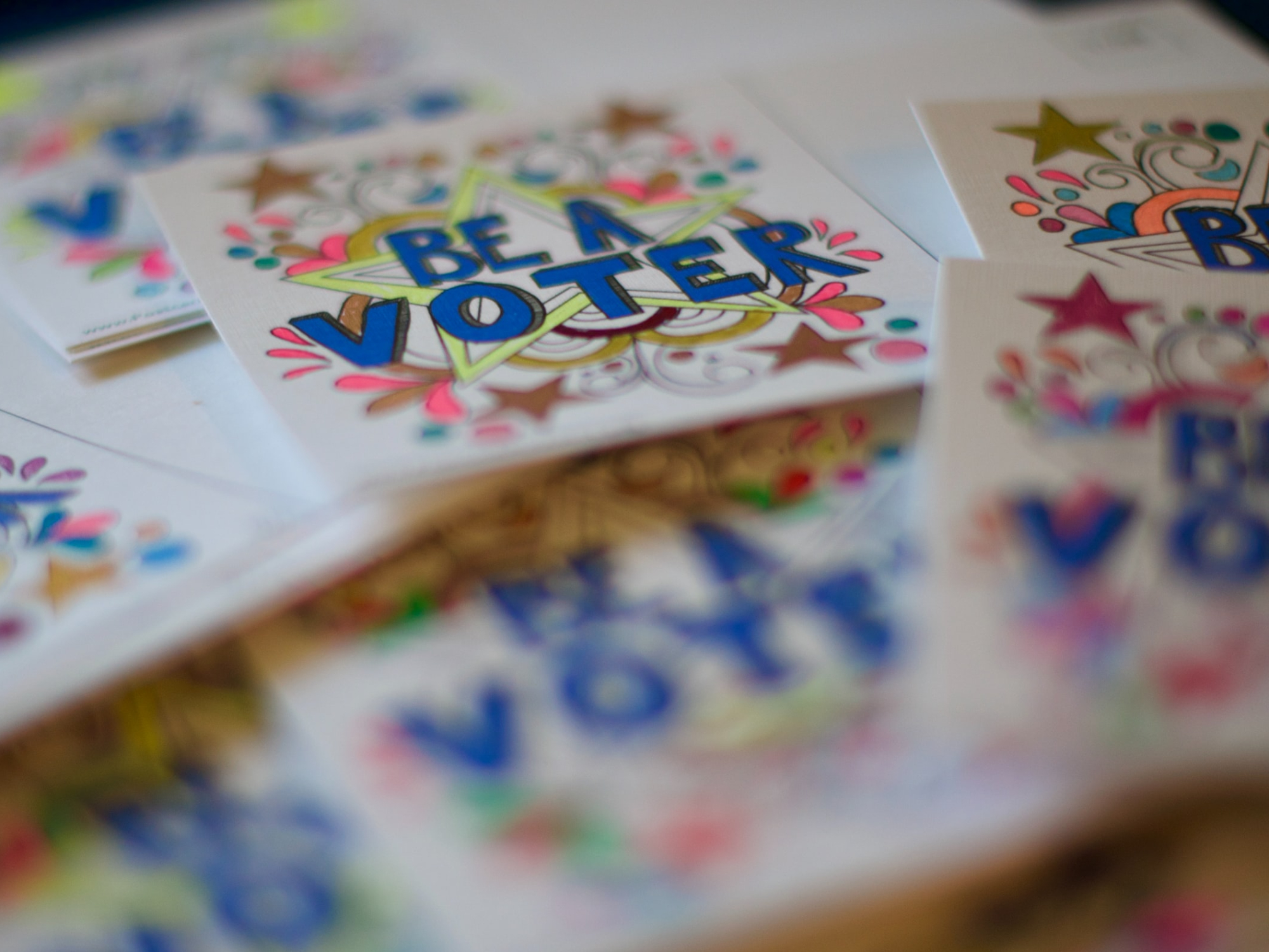 a photo of stickers or cards that say "be a voter"