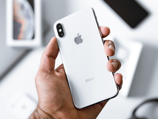 a person holding a white Apple iPhone in their hand