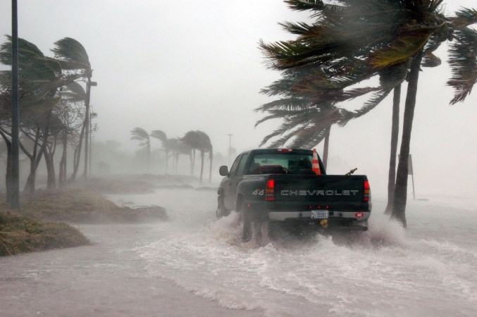 truck driving through water on beach as hurricane moves in